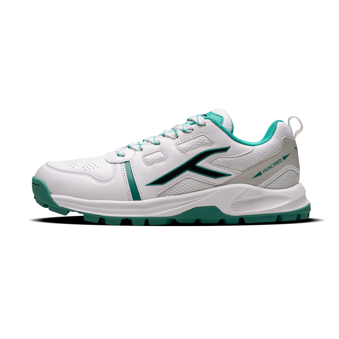 A white HUNDRED Hyper Turf cricket shoe with green accents and a rubber studded outsole.